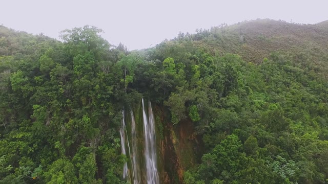 The View On High Waterfall In The Middle Of A Dense Tropical Green Forest