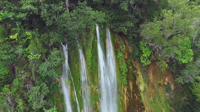 Huge Flows Of Water From A Waterfall Pouring Over The Green Slopes