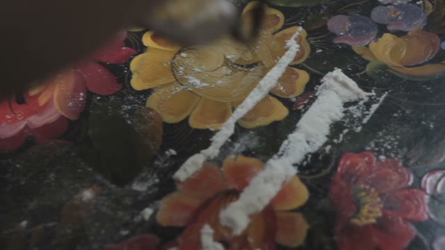 Man Sniffing White Powder Narcotic Directly From The Patterned Tray