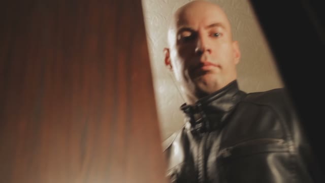 A Man In A Leather Jacket Took Out A Knife Opening A Wardrobe