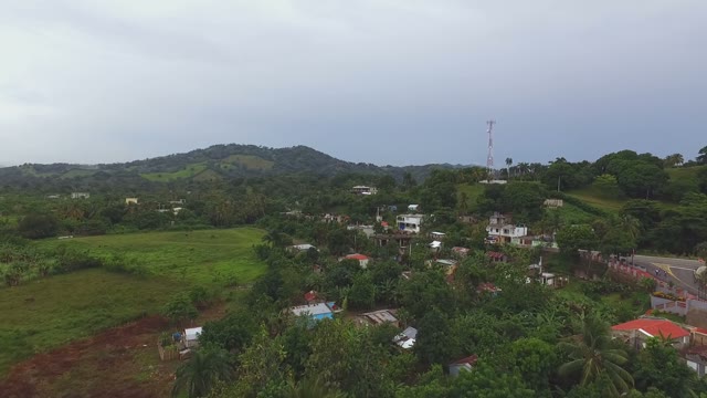 View From The Air In A Small Town Surrounded By Green Mountains And Trees