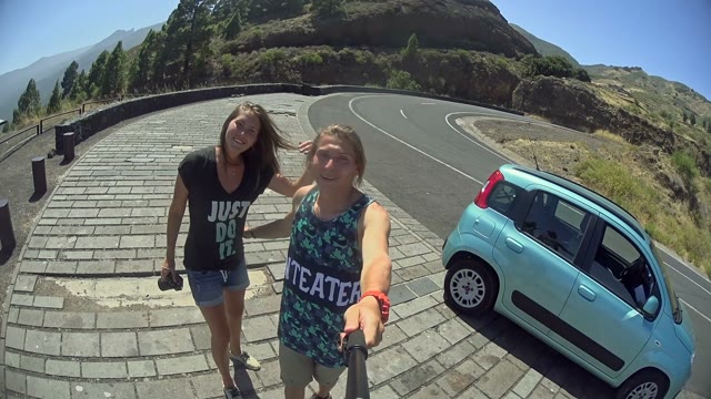 A Couple Filming Themselves On A Hill During A Road Trip