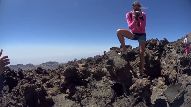 Woman Filming A Man Standing On The Top