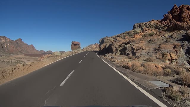 Car Is Moving Up The Road Surrounded By Rocks