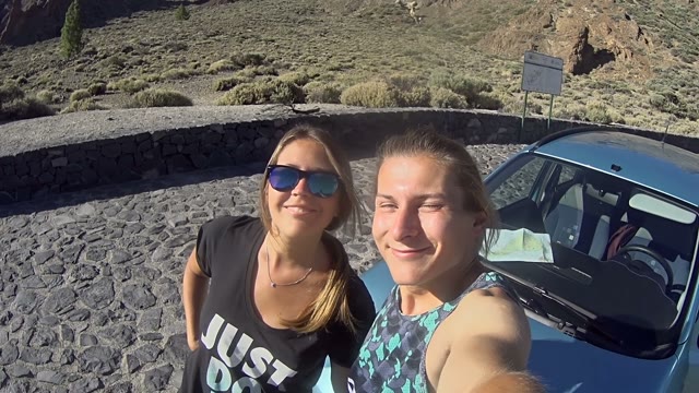 Young Couple Filming Themselves Outdoors Next To Car
