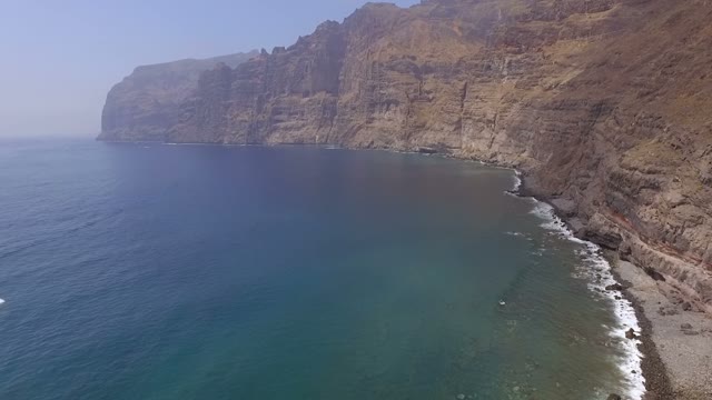 A Little Ship In The Open Sea Near The Rocky Coastline, Aerial