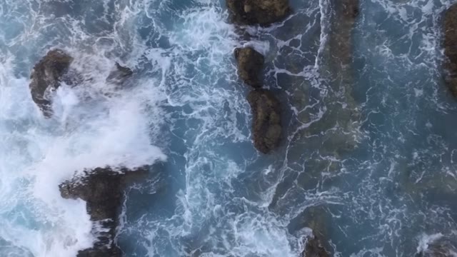 Woman Standing On Rocks In The Sea