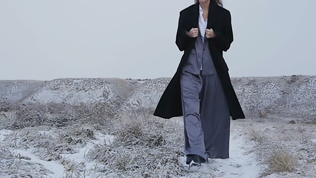 The Girl In A Suit Buttons Her Coat In The Cold