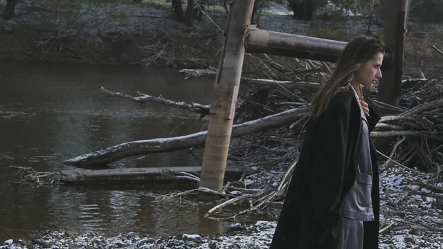 Pretty Girl In A Suit Against The Backdrop Of The River And Dry Branches