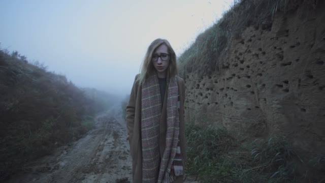 Girl With Blond Hair Wandering In The Fog