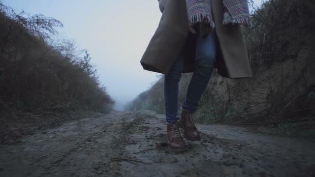 Legs Of A Girl Go On A Dirt Road In The Woods