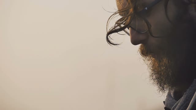 Bearded Man Smokes A Cigarette On A Background Of Sky At Sunset