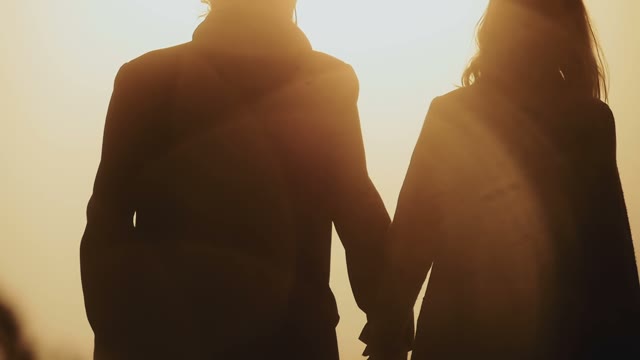 Loving Couple In The Sunny Light Go Together By The Hand