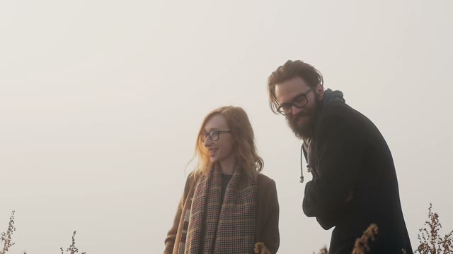A Pair Of Hipster With Glasses Laughing In The Background Of Sunset