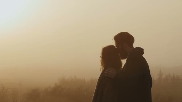 The Guy Holds The Girl By The Shoulders Against The Evening Sunset