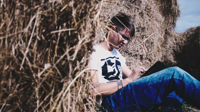 The Guy With Glasses Among The Many Haystacks Working In A Laptop