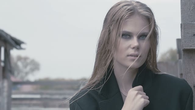 Pretty Blond Girl In A Black Coat Posing For Photo