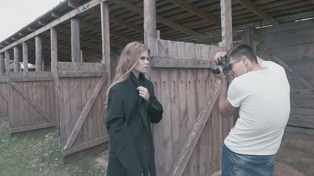 Beautiful Blond Girl In A Black Coat Posing For The Photographer