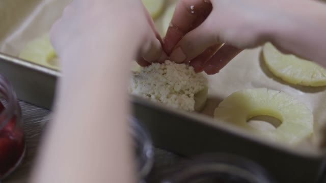 Hands Lay Out Curd On Slices Of Pineapple Close-up