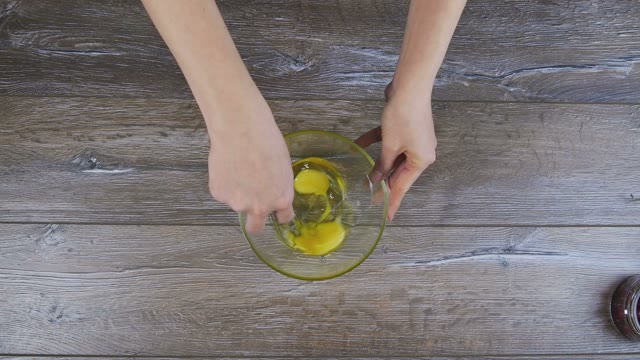 Female Hand Is Whipped The Eggs In A Bowl