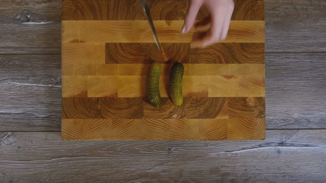 Women Hands Sliced Pickled Cucumbers
