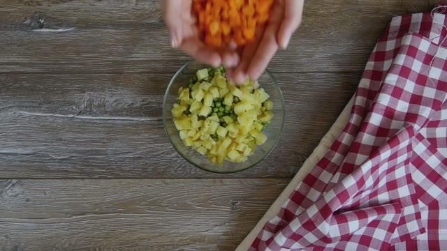 Cook Adds Carrot Slices To A Salad
