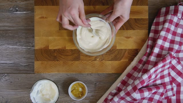 Cook Stirs The Sauce In A Glass Bowl