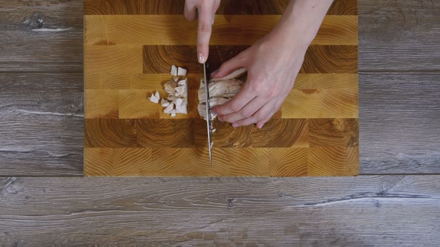 Female Hands Sliced Chicken Breast Into Pieces