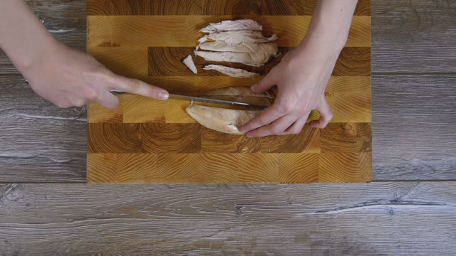 Female Hands Sliced Chicken Breast Into Pieces