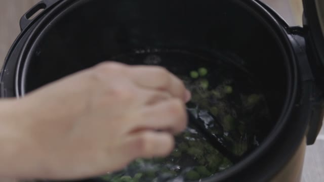 Female Hand Shuffles Peas In Water Close-up