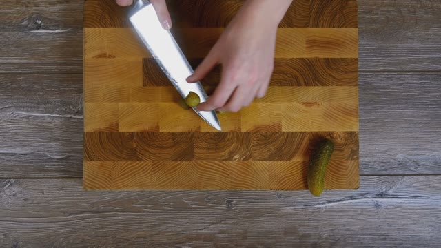 Women Hands Sliced Pickled Cucumbers