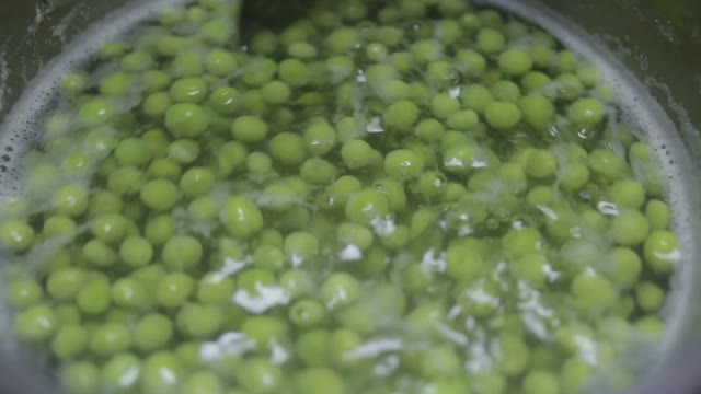 Spoon Mixing Peas In Water Close-up