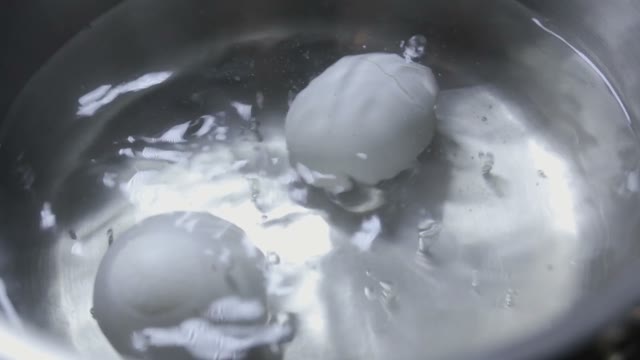 Two Eggs Are Cooked In Boiling Water Close-up