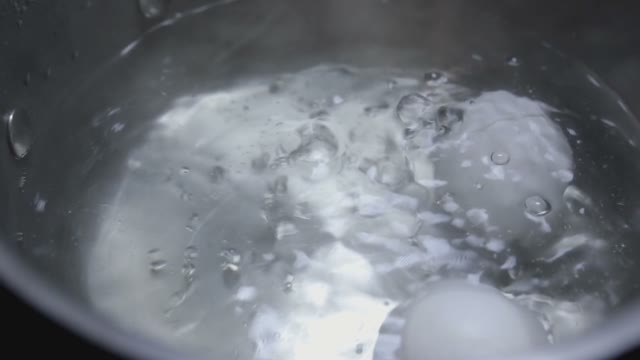 Two Eggs Are Cooked In Boiling Water Close-up