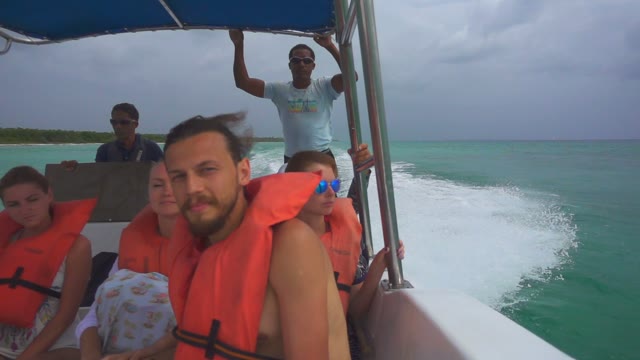 Travellers On A Boat In Lifejackets Floating In The Ocean