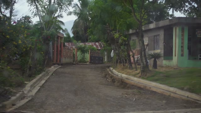 The View From A Passing Car In The Local Village, Houses, Shack During Heavy