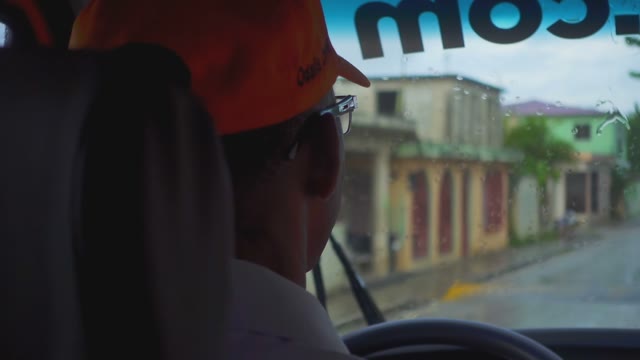 The Driver In The Cap In The Car During Rainy Weather