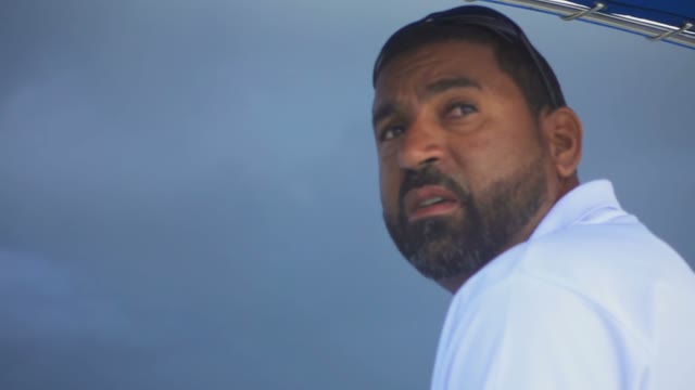 The Dark-skinned Man In A Boat Looking Around During A Storm