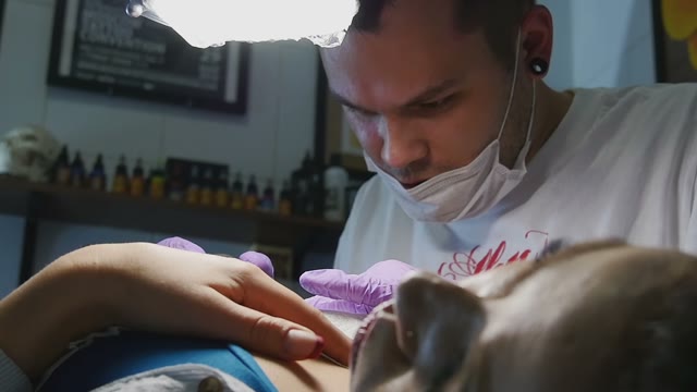 Tattoo Master Makes The Tattoo On A Woman's Body