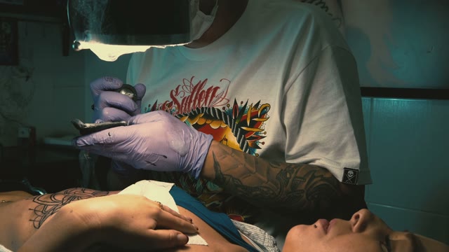 Tattoo Master Makes The Tattoo On A Woman's Body