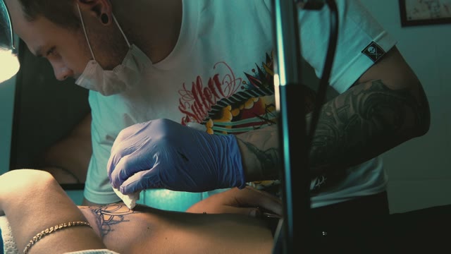 Tattoo Master Makes The Tattoo On A Woman's Body Close-up