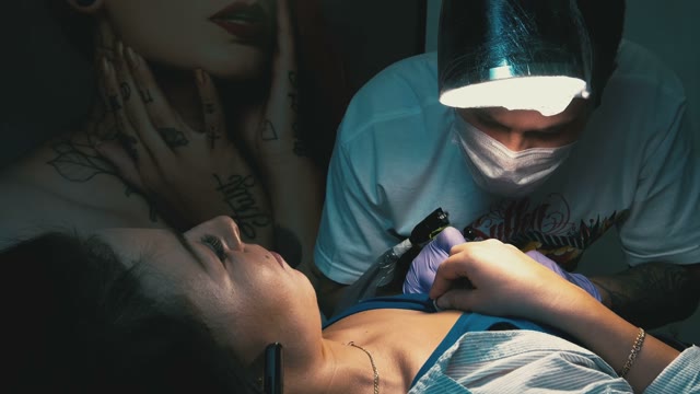 Tattoo Master Makes The Tattoo On A Woman's Body
