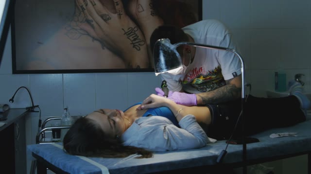 Tattoo Master Makes The Tattoo On A Woman's Body