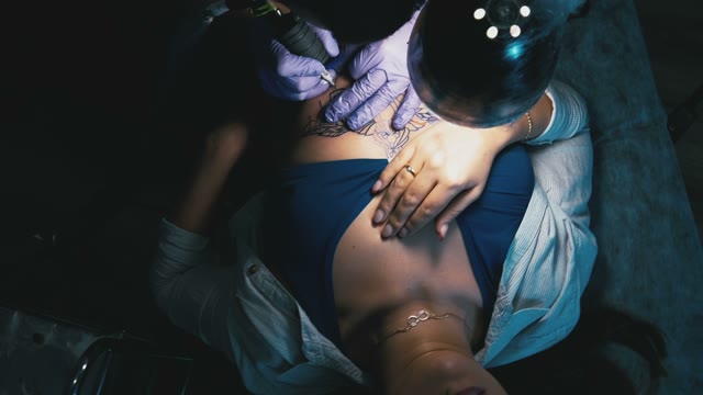 Tattoo Master Makes The Tattoo On A Woman's Body