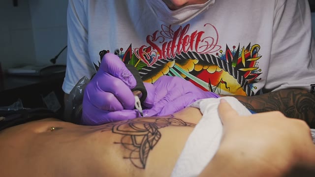 Tattoo Master Makes The Tattoo On A Woman's Body