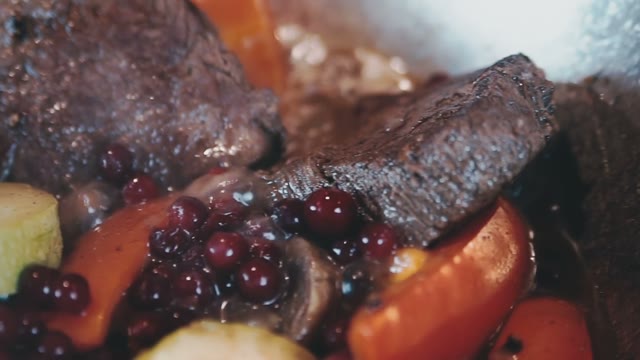 Vegetables And Meat Stewed With Berries Over An Open Flame
