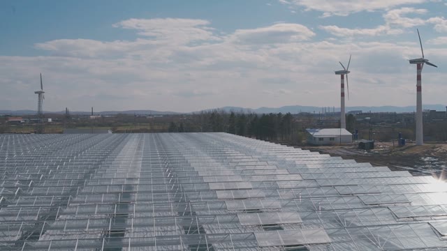 A Lot Of Glass Greenhouses Roofs And Windmills