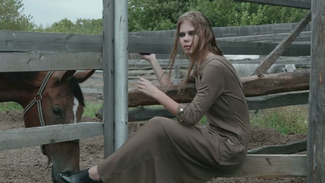 Girl Sitting Next To A Horse Paddock