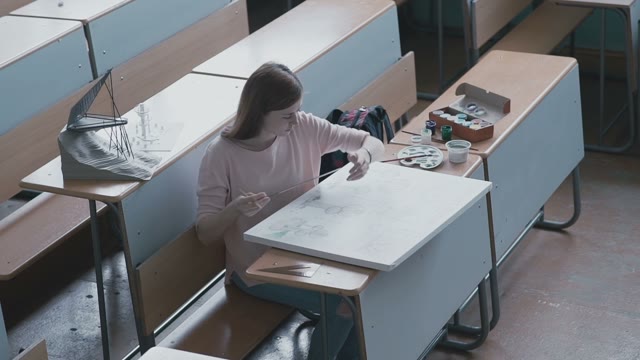 The Girl Student In A Pink Blouse Measures The Drawing Using A Ruler