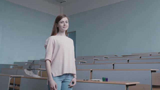 The Girl Student In A Pink Blouse Standing In An Empty Classroom